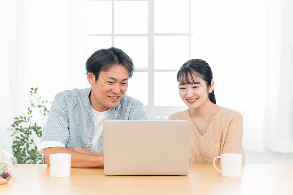 パソコンを見る夫婦
