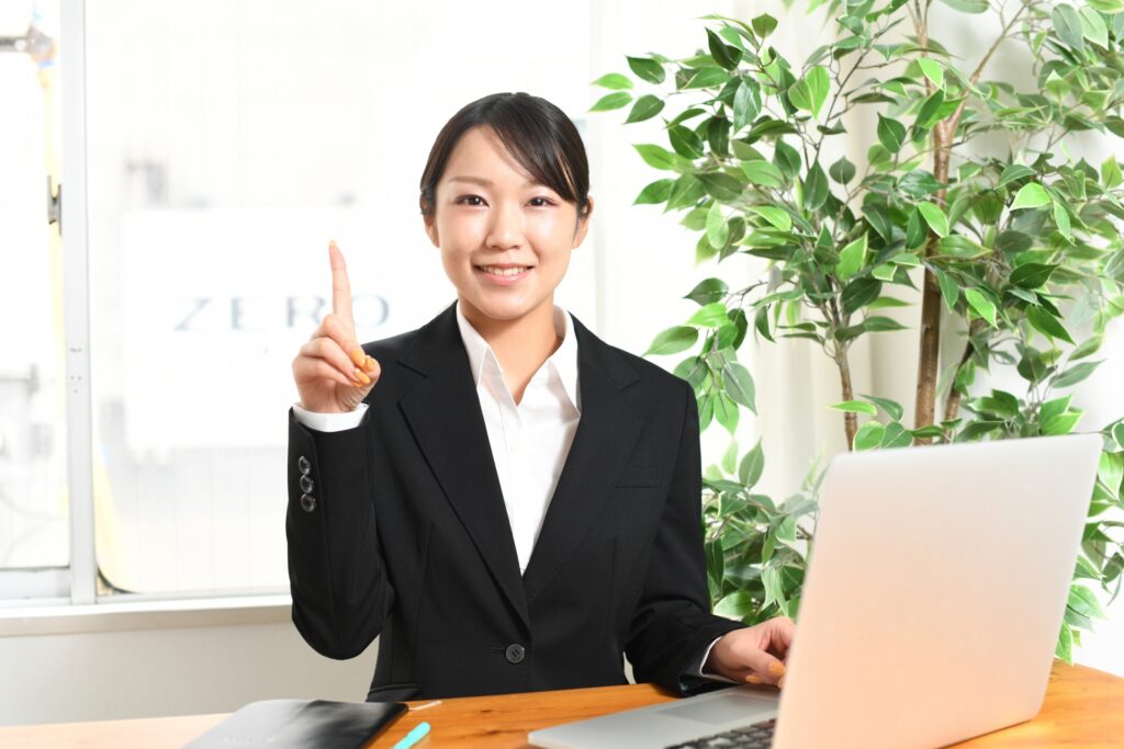 人差し指をたてる女性スタッフ