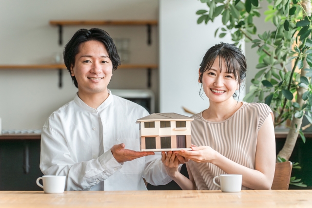 パソコン模型を持つ笑顔の夫婦